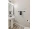 Modern powder room featuring pedestal sink and black accessories at 6525 Raven Hall St, North Las Vegas, NV 89084