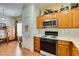 Cozy kitchen features wooden cabinets, stainless steel microwave, and gas burning stovetop at 6549 Clara Bow Ave # 103, Las Vegas, NV 89122