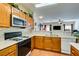 Functional kitchen boasting wood cabinets, white countertops, and a view into the living area at 6549 Clara Bow Ave # 103, Las Vegas, NV 89122
