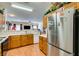 Well-lit kitchen with wood cabinetry, stainless steel refrigerator, and view to the open living space at 6549 Clara Bow Ave # 103, Las Vegas, NV 89122