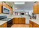 Functional kitchen boasting wood cabinets, white countertops, and a view into the living area at 6549 Clara Bow Ave # 103, Las Vegas, NV 89122