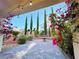Landscaped backyard featuring a fountain, brick-paved patio, mature trees, and vibrant bougainvillea at 7083 Seat Wall Rd, Las Vegas, NV 89148