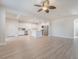 Open-concept living room with a modern ceiling fan, light wood floors, and a view into the kitchen at 7083 Seat Wall Rd, Las Vegas, NV 89148