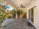 Covered patio features a ceiling fan, lush plants, and an elegant brick-paved floor for relaxation and outdoor entertaining at 7083 Seat Wall Rd, Las Vegas, NV 89148