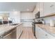 Well-lit kitchen with white cabinets, granite countertops, and modern stainless steel appliances including a gas range at 7107 Calvert Cliffs St, North Las Vegas, NV 89084
