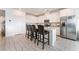 Well-lit kitchen with white cabinetry, an island with seating, and stainless steel appliances at 7107 Calvert Cliffs St, North Las Vegas, NV 89084