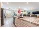 Spacious kitchen with white cabinets, granite countertops, and stainless steel appliances open to the living area at 7107 Calvert Cliffs St, North Las Vegas, NV 89084