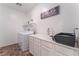Well-organized laundry room with washer, dryer, folding counter, and storage cabinets at 7107 Calvert Cliffs St, North Las Vegas, NV 89084