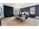 The Main bedroom boasts a modern design with a dark accent wall, neutral carpet, and lots of natural light at 7107 Calvert Cliffs St, North Las Vegas, NV 89084