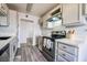 Well-lit kitchen showcasing stainless steel appliances, gray cabinetry, and gray wood-style flooring at 745 N Royal Crest Cir # 141, Las Vegas, NV 89169