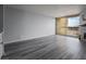 Spacious living room featuring gray wood floors, stone fireplace, and a sliding glass door to a balcony at 745 N Royal Crest Cir # 141, Las Vegas, NV 89169