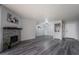 Stylish living room with a decorative stone fireplace, gray wood floors, and a small wet bar at 745 N Royal Crest Cir # 141, Las Vegas, NV 89169