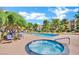Community pool and hot tub area surrounded by lounge chairs and lush landscaping at 745 N Royal Crest Cir # 141, Las Vegas, NV 89169