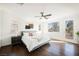 Primary bedroom featuring wood floors, a ceiling fan, and natural light from multiple windows at 7466 Matilda St, Las Vegas, NV 89113