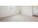 Empty bedroom with neutral carpet, white walls, and a window for natural light at 7466 Matilda St, Las Vegas, NV 89113