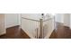 Upstairs hallway with hardwood flooring and white railings, leading towards the stairwell at 7466 Matilda St, Las Vegas, NV 89113