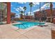 Sparkling community pool with lounge chairs and umbrellas, surrounded by palm trees and attractive buildings at 75 E Agate Ave # 206, Las Vegas, NV 89123