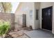Cozy gated front entrance featuring a black steel door, decorative stone, and mature landscaping at 7754 Pink Ginger St, Las Vegas, NV 89123
