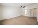 Bright main bedroom featuring neutral carpet, ceiling fan, and attached bathroom at 7754 Pink Ginger St, Las Vegas, NV 89123