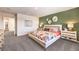 A primary bedroom with a stylish green accent wall, neutral carpet, and light-colored furniture with gold accents at 790 Calm Crystal Ct # Lot 140, North Las Vegas, NV 89081