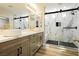 Beautiful bathroom featuring dual sinks, marble countertops, wood cabinets, and a glass enclosed shower at 8095 Carpenter Creek Ave, Las Vegas, NV 89113