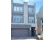 Contemporary gray three-story home featuring a garage, rooftop deck, and manicured front yard at 8095 Carpenter Creek Ave, Las Vegas, NV 89113