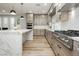 Bright kitchen features an island with a marble countertop, wood-colored cabinets, and stainless steel appliances at 8095 Carpenter Creek Ave, Las Vegas, NV 89113