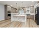 A modern kitchen featuring a marble waterfall island, stainless steel appliances, and light wood-colored cabinets at 8095 Carpenter Creek Ave, Las Vegas, NV 89113
