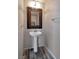 Stylish powder room with a pedestal sink, decorative mirror, and modern fixtures at 8152 Satin Carnation Ln, Las Vegas, NV 89166