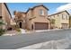 Inviting two-story home with a brown garage door, desert landscaping and neutral-toned stucco facade at 8152 Satin Carnation Ln, Las Vegas, NV 89166