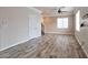 Spacious living room featuring wood-look floors, neutral walls, and ample natural light from large windows at 8152 Satin Carnation Ln, Las Vegas, NV 89166
