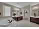 A bathroom featuring a soaking tub, double sink vanity and walk in closet at 9046 Barium Rock Ave, Las Vegas, NV 89143