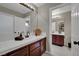 Well-lit bathroom features a double sink with cherry wood cabinetry and decorative accents at 9046 Barium Rock Ave, Las Vegas, NV 89143
