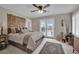 Serene bedroom with an area rug, glass doors to a balcony, neutral color palette and decor at 9046 Barium Rock Ave, Las Vegas, NV 89143
