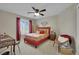 Cozy bedroom with red accents, a ceiling fan, and a bright window provides comfort and style at 9046 Barium Rock Ave, Las Vegas, NV 89143