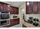 A kitchen showcasing granite countertops, stainless steel double oven and rich wood cabinetry at 9046 Barium Rock Ave, Las Vegas, NV 89143