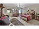 This main bedroom features natural lighting from the windows and a stylish chandelier at 9046 Barium Rock Ave, Las Vegas, NV 89143