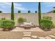Inviting outdoor seating area with a comfortable couch and lush landscaping, perfect for relaxation at 9046 Barium Rock Ave, Las Vegas, NV 89143