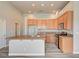 Kitchen with island, granite countertops, wood cabinetry, and plank flooring at 9137 Big Plantation Ave, Las Vegas, NV 89143