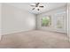 Spacious carpeted bedroom with a ceiling fan, natural light, and a glass door at 9282 W Viking Rd, Las Vegas, NV 89147