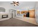 Open concept living room with fireplace flows into the kitchen with black appliances at 9282 W Viking Rd, Las Vegas, NV 89147