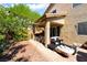 Landscaped backyard featuring a covered patio with outdoor seating, string lights, and shade trees at 9513 Perennial View Ave, Las Vegas, NV 89148