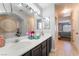 Well-lit bathroom with dual sinks, expansive vanity, and soaking tub at 9513 Perennial View Ave, Las Vegas, NV 89148