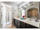 Bright bathroom featuring double sinks, a large mirror, and a separate shower and bathtub at 9513 Perennial View Ave, Las Vegas, NV 89148
