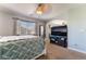 Carpeted bedroom with ceiling fan, Queen bed, and views of the lush exterior at 9513 Perennial View Ave, Las Vegas, NV 89148