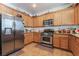Traditional kitchen features stainless steel appliances, tile floor and light wood cabinets at 9513 Perennial View Ave, Las Vegas, NV 89148