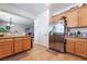 Open kitchen layout featuring tile floors, wooden cabinets, and stainless steel refrigerator at 9513 Perennial View Ave, Las Vegas, NV 89148