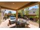 Covered patio featuring a table and chairs, sofa, manicured landscaping, and string lights at 9513 Perennial View Ave, Las Vegas, NV 89148