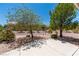 Lush backyard with mature trees, gravel landscaping, and a cozy bench, perfect for relaxing at 10301 Coal Creek Pl, Las Vegas, NV 89134