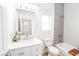 Bathroom featuring a white vanity with marble countertop, tub with tiled surround and modern fixtures at 10301 Coal Creek Pl, Las Vegas, NV 89134